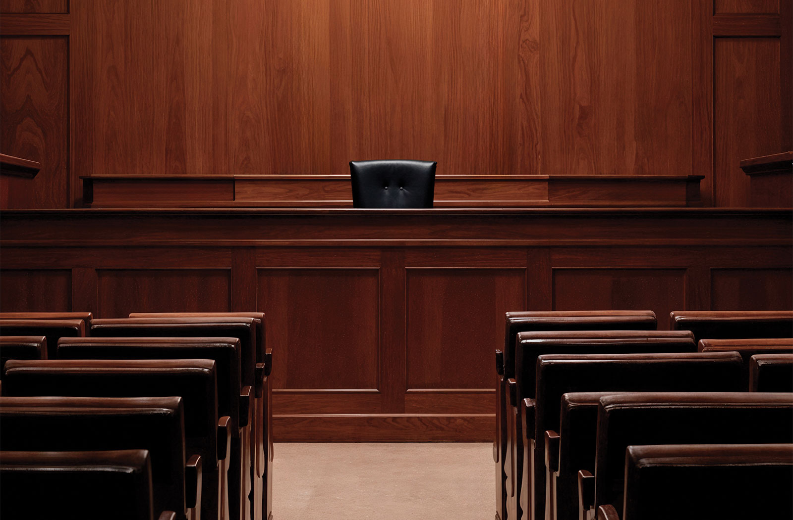 Empty courtroom with judge's bench and rows of seating