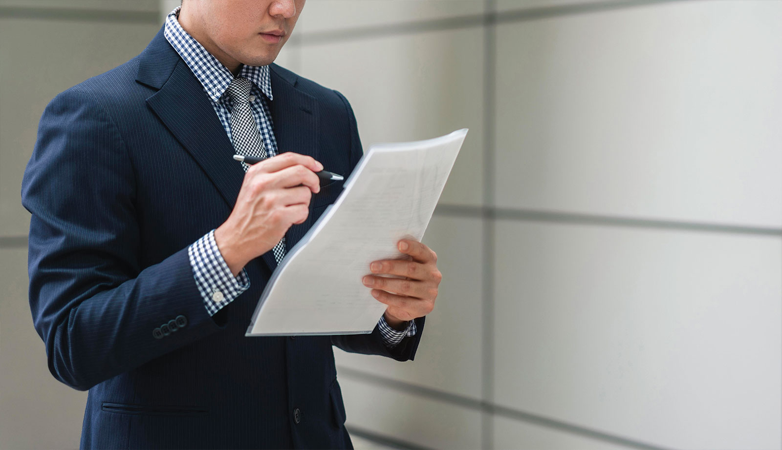 Businessman reviewing a document while holding a pen