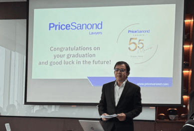 A speaker standing in front of a projector screen displaying PriceSanond's congratulatory graduation message to interns.